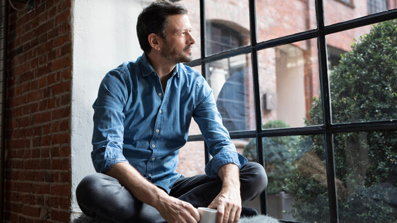 Man drinking coffee and looking out window