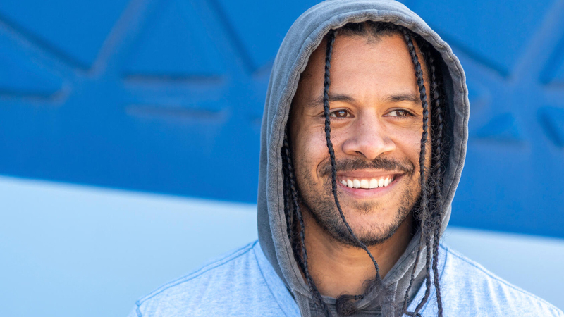 Man in a hoodie smiling at the camera