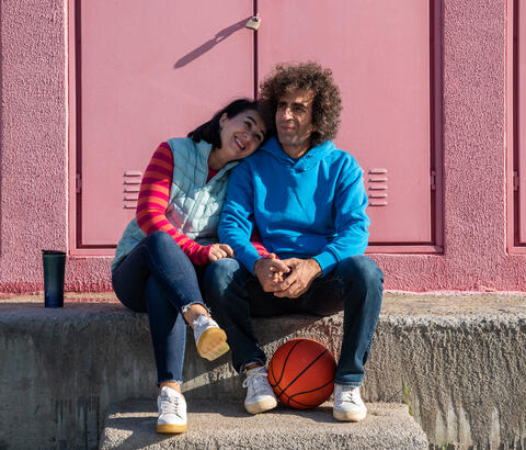 Couple sitting together with a basketball