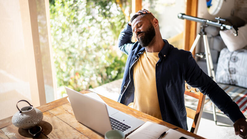 Man stretching at his desk