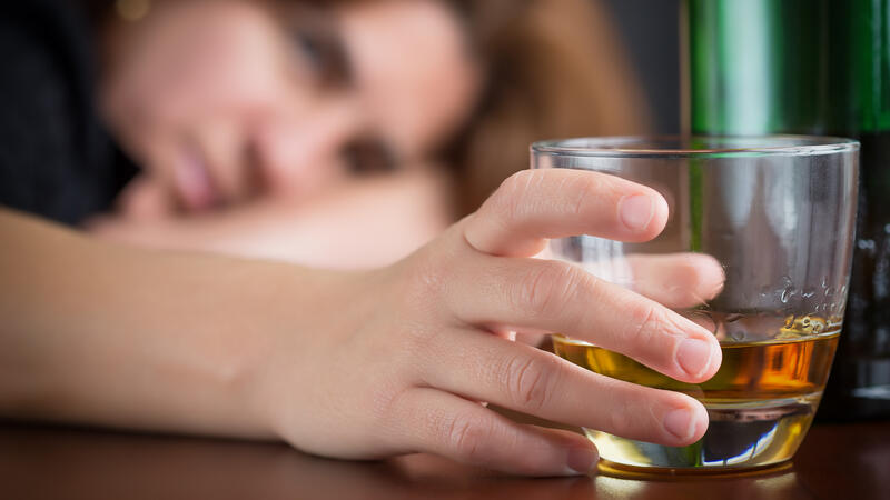 Closeup on hand holding a glass of alcohol