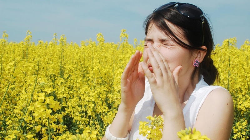 Woman sneezing in a field