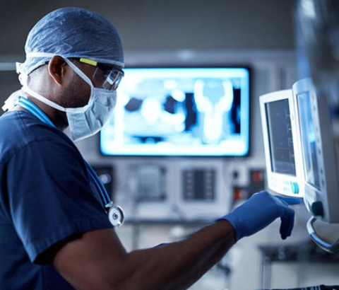 Masked doctor looking at monitors