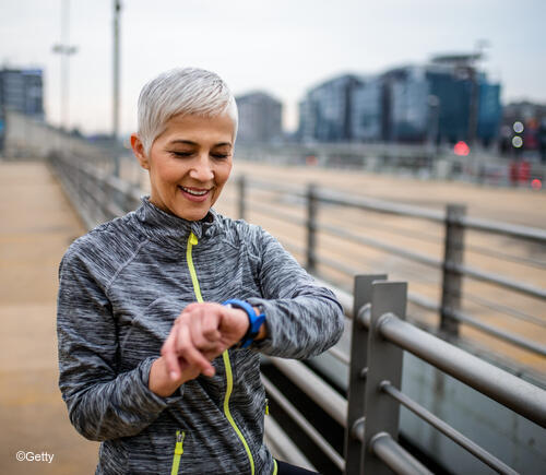 Adult woman checking fitness tracking watch.