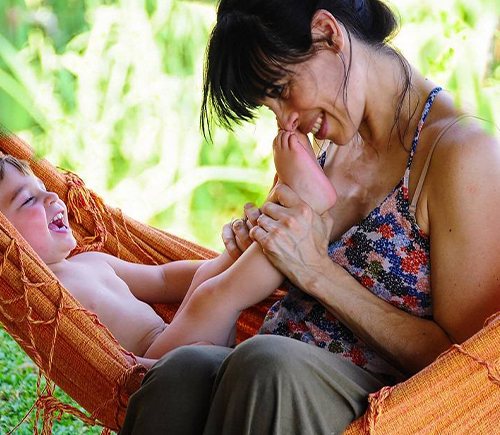 Mother playing with smiling young child