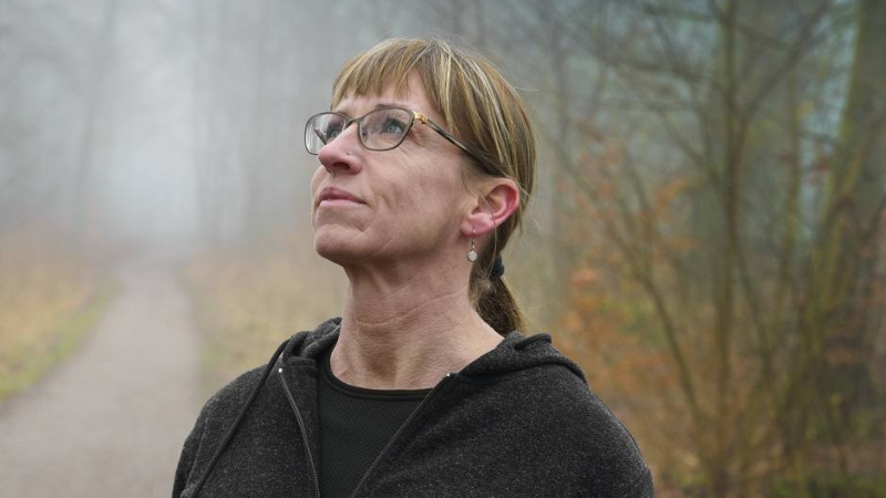 Woman in woods looking up slightly