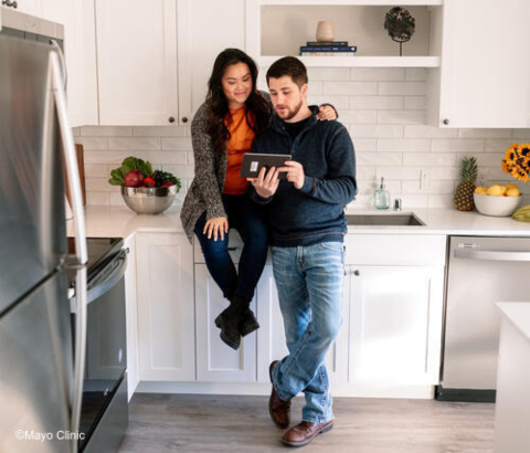 Couple looking at e-tablet in their kitchen
