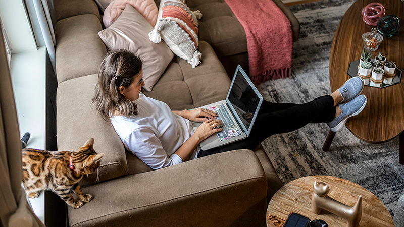 Woman sitting on a sofa working on her laptop