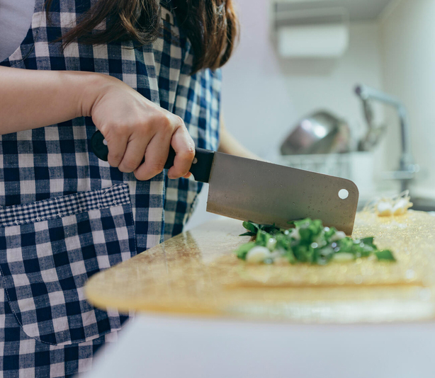 Person chopping herbs on cutting board