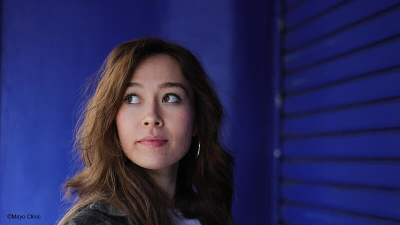 Woman standing in front of blue wall