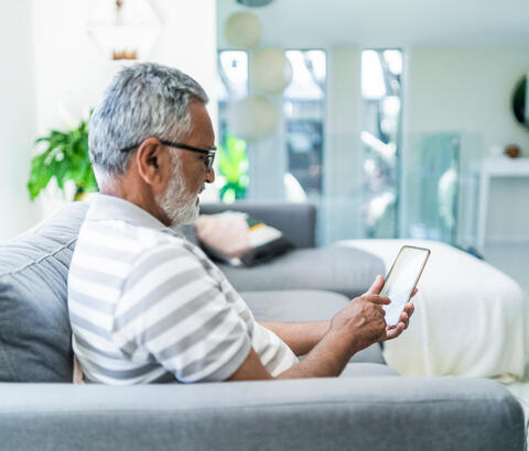 Man using smartphone at home