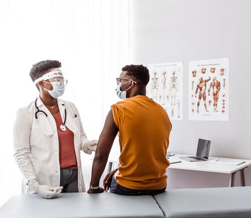 Patient and doctor wearing face masks in exam room