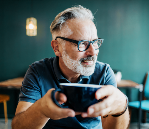 Man smiling and drinking coffee