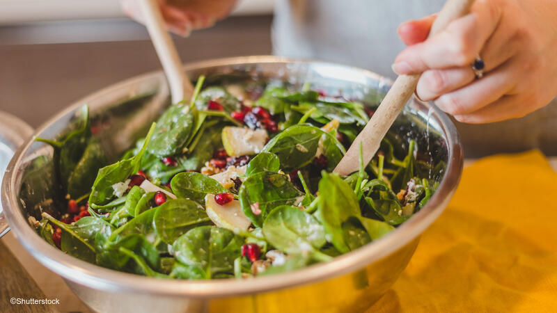 Woman preparing a salad in a large bowl