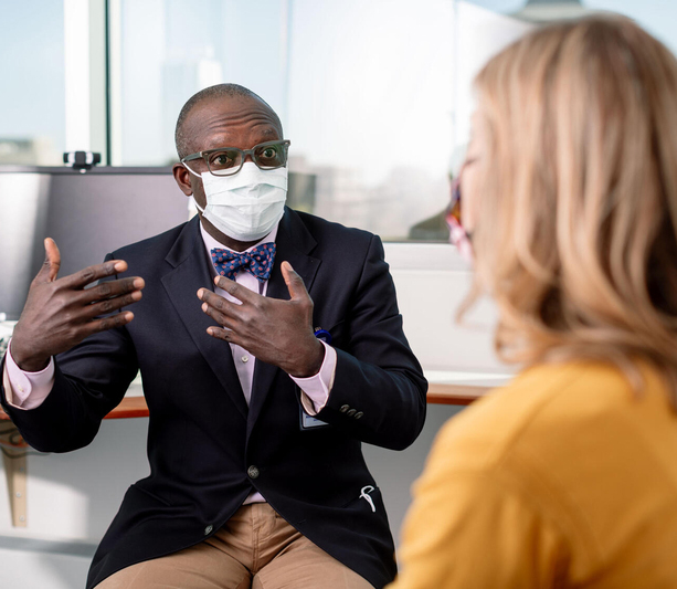 Masked doctor explaining to patient