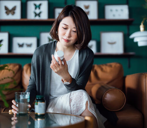 Woman looking at supplement bottle