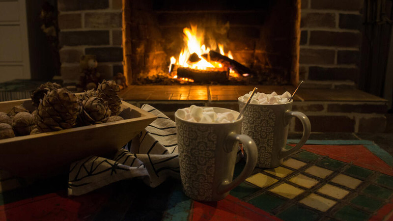 Cups of hot cocoa in front of a fire