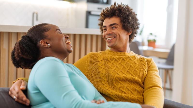 Couple laughing together on the couch