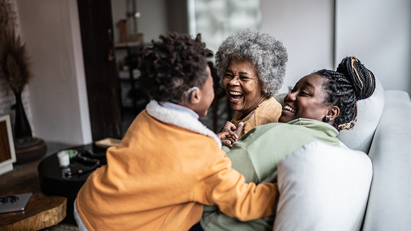 Family laughing together on a sofa