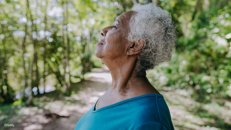 Woman taking a deep breath outside