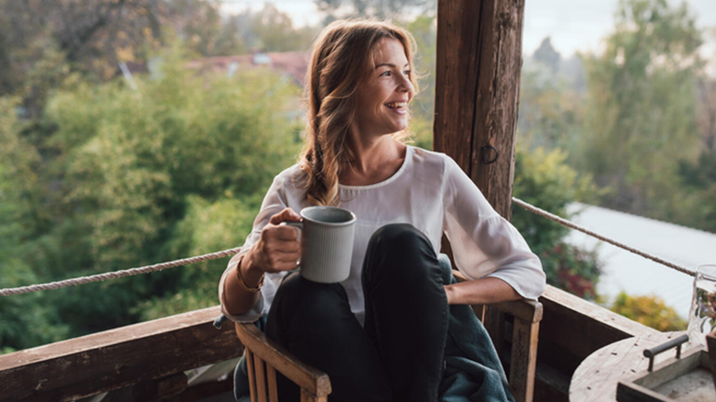 Woman drinking her coffee on her deck