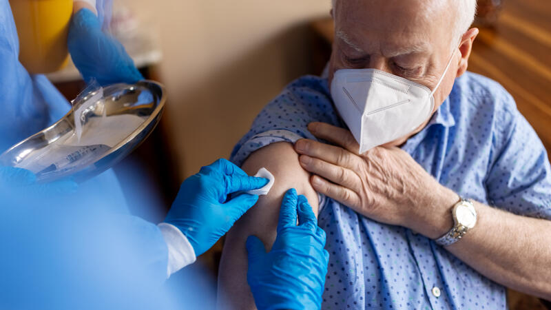 Older adult man receiving a vaccination