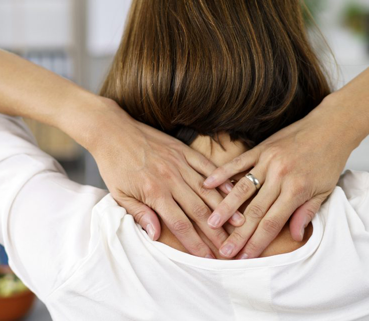 Woman with hand on neck