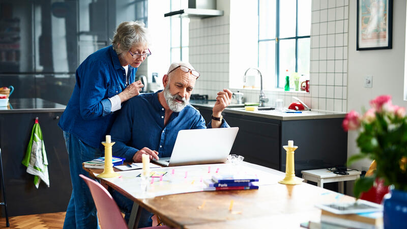 Older adult couple looking at a laptop