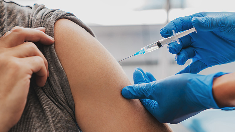 Woman getting a vaccine in her left shoulder