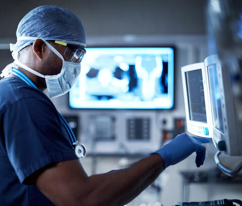 Masked doctor checking monitor