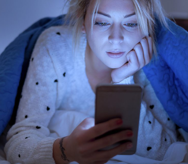 Woman looking at phone in the dark