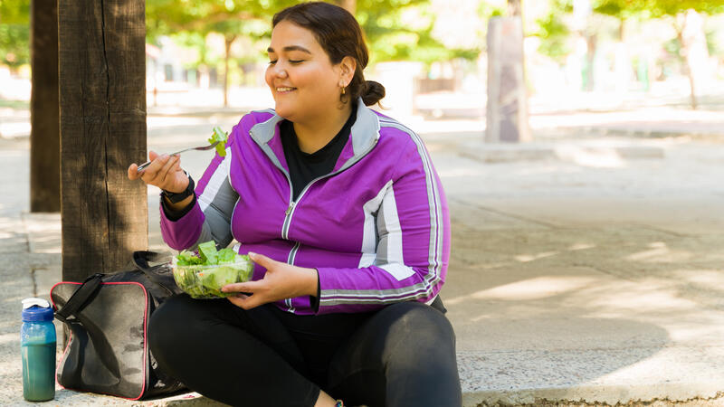 Woman eating a salad outside