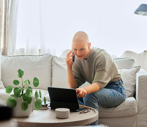 Person with shaved head working on e-tablet