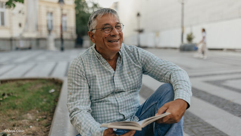 Older adult man reading outside