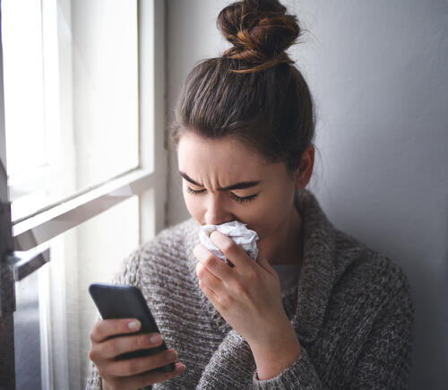 Sick woman looking at her phone