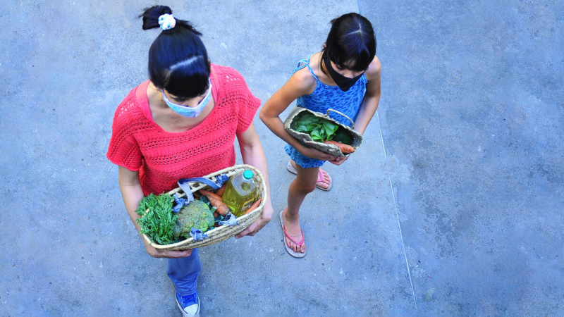 Mom and daughter carrying groceries