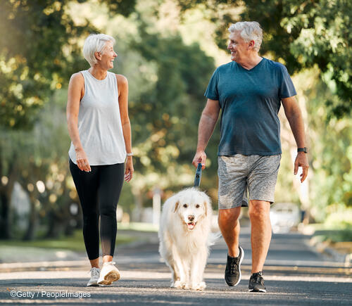 Older adult couple walking their dog