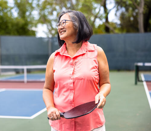 Older woman holding a pickleball paddle