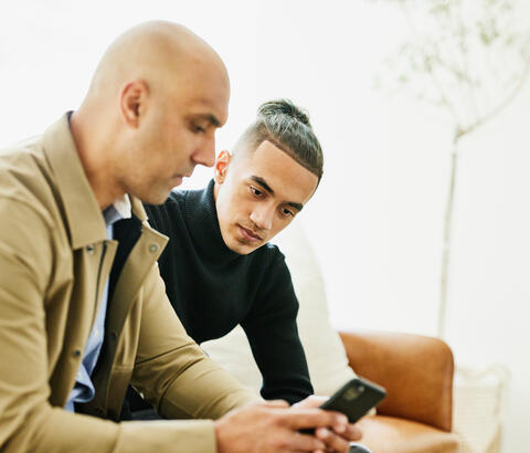 Two men looking at a smartphone