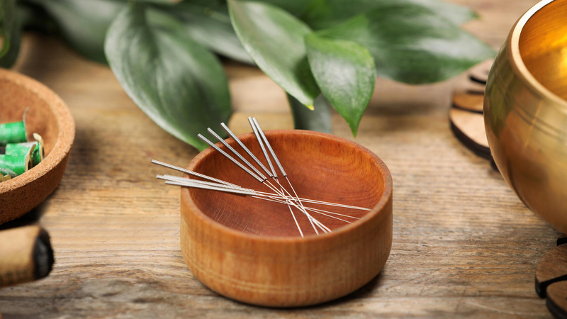 Acpuncture needles in a wooden bowl