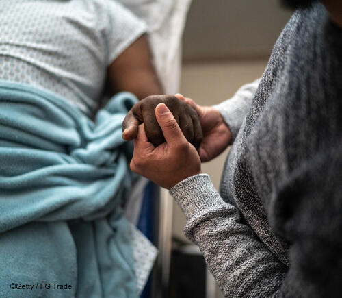 Person holding a patient's hand