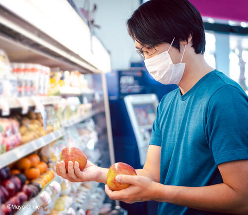 Man holding apples in grocery store