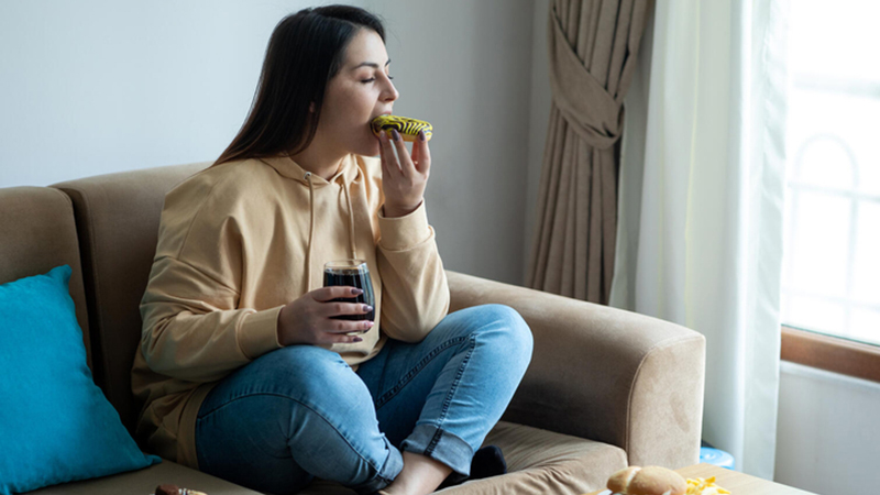 Woman eating food on the couch