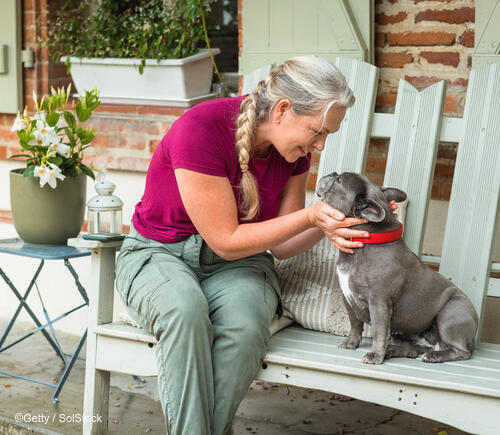 Woman petting her dog on the proch