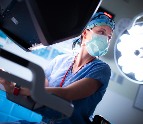 Woman with mask under operating lights