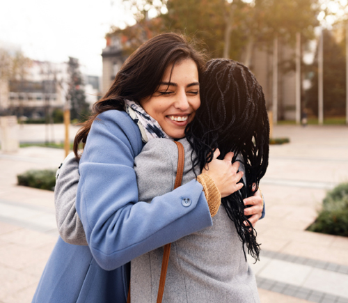 Two women embracing each other