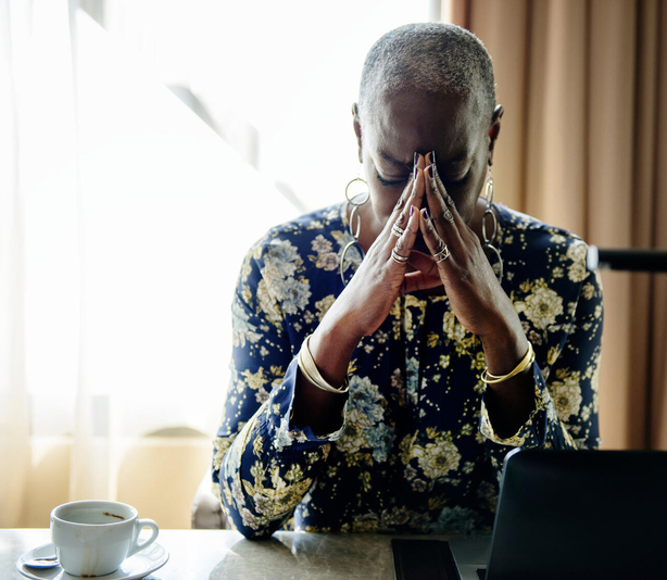 Woman with head in hands at dining table