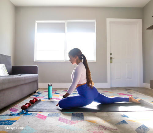 Young woman doing yoga inside