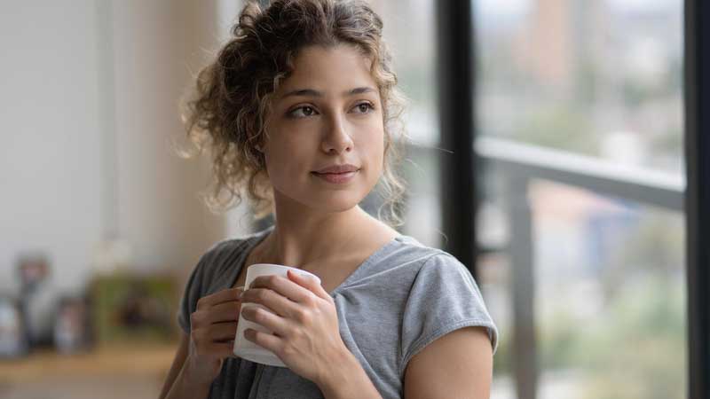 Woman looking pensively out a window