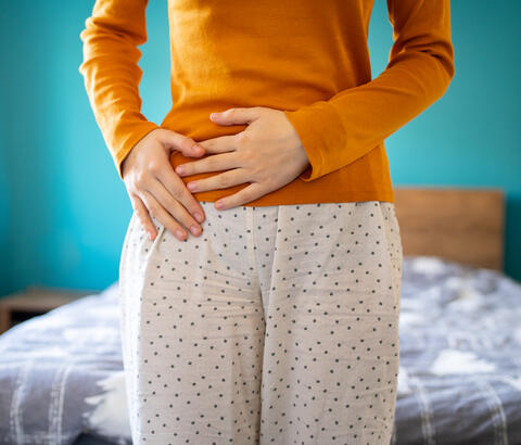 Woman holding her hands to her stomach